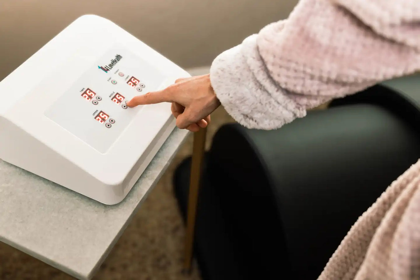Person pressing the Infrared Sauna Dome By 1Love controller