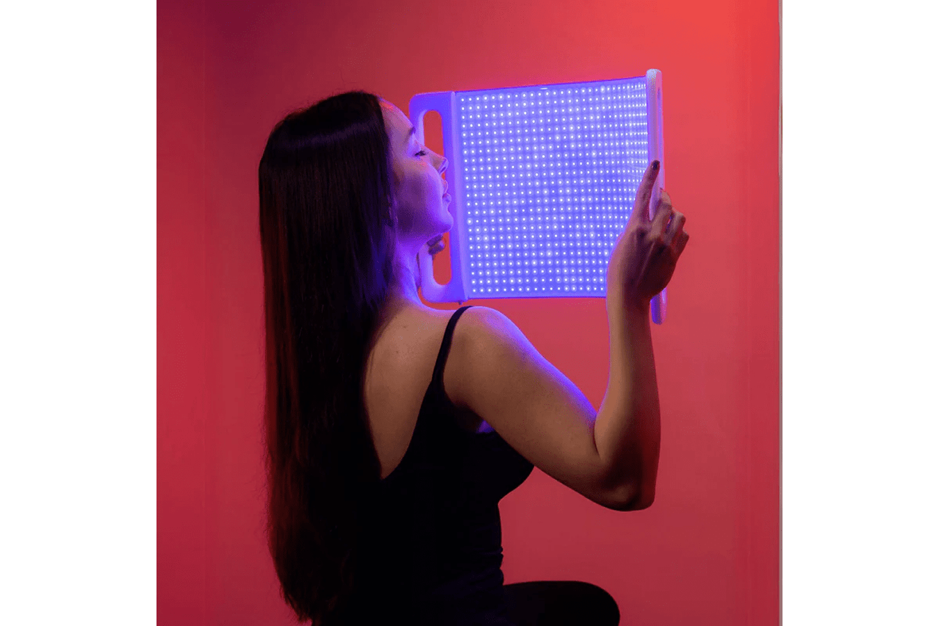 Lady holding a Lumara Illuminate Blue Professional Blue Light Therapy Panel
