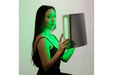 Lady holding a Lumara Illuminate Green Professional Green Light Therapy Panel
