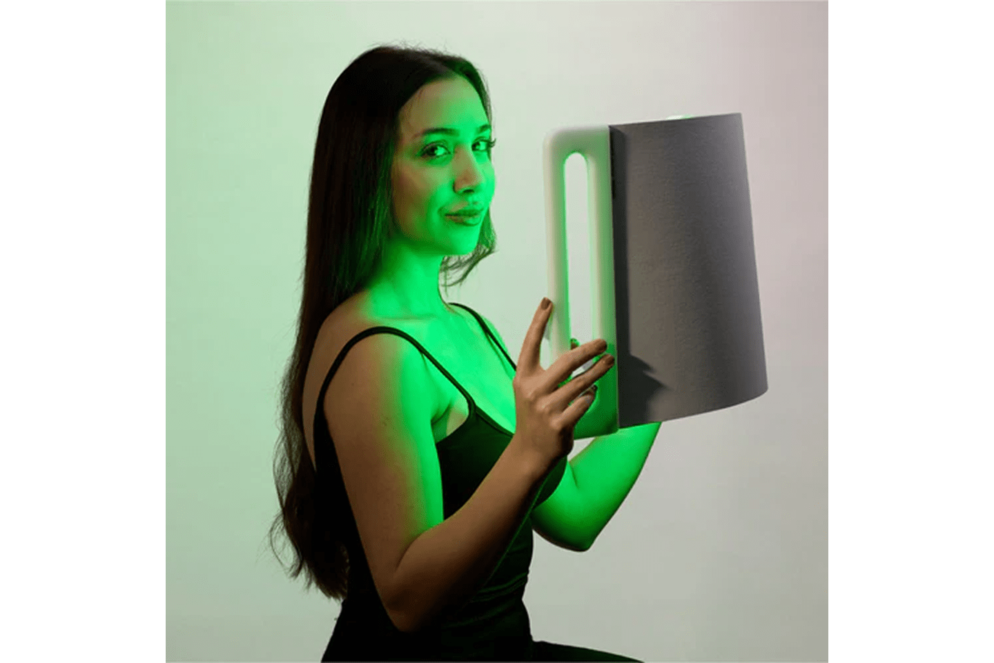 Lady holding a Lumara Illuminate Green Professional Green Light Therapy Panel