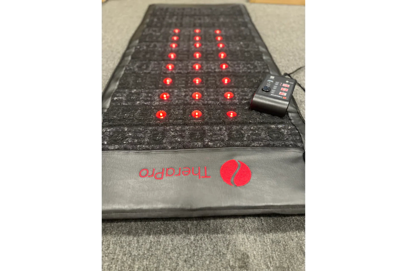 Therasage Red Light Therapy Pad with controller on the surface