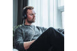 Person using the Stratus 3.0 ear insufflation headset while relaxing at home