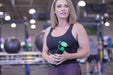 Woman holding a Rapid Release Pro3+ massager in a gym