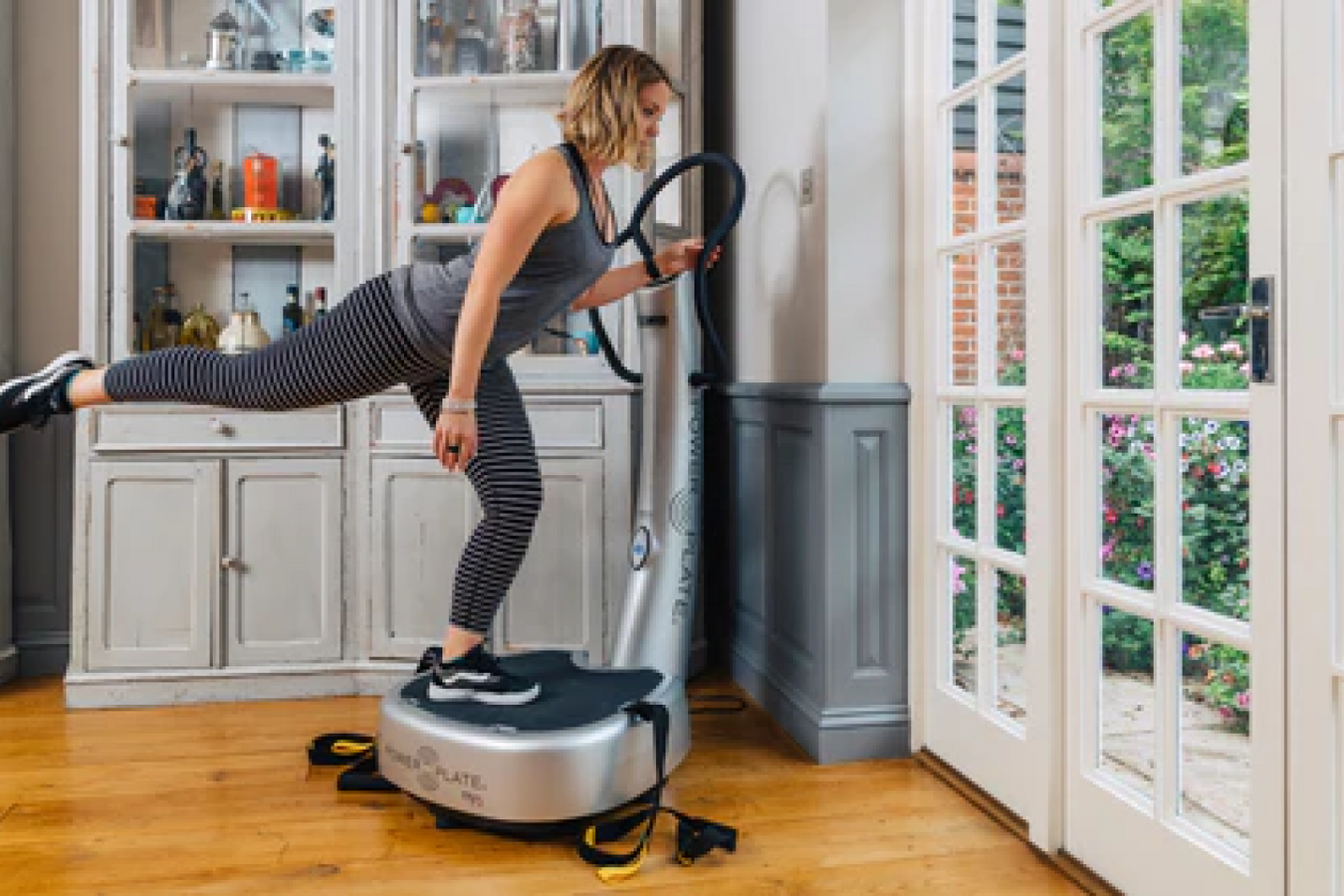Person holding the Power Plate Machine handles while doing workout