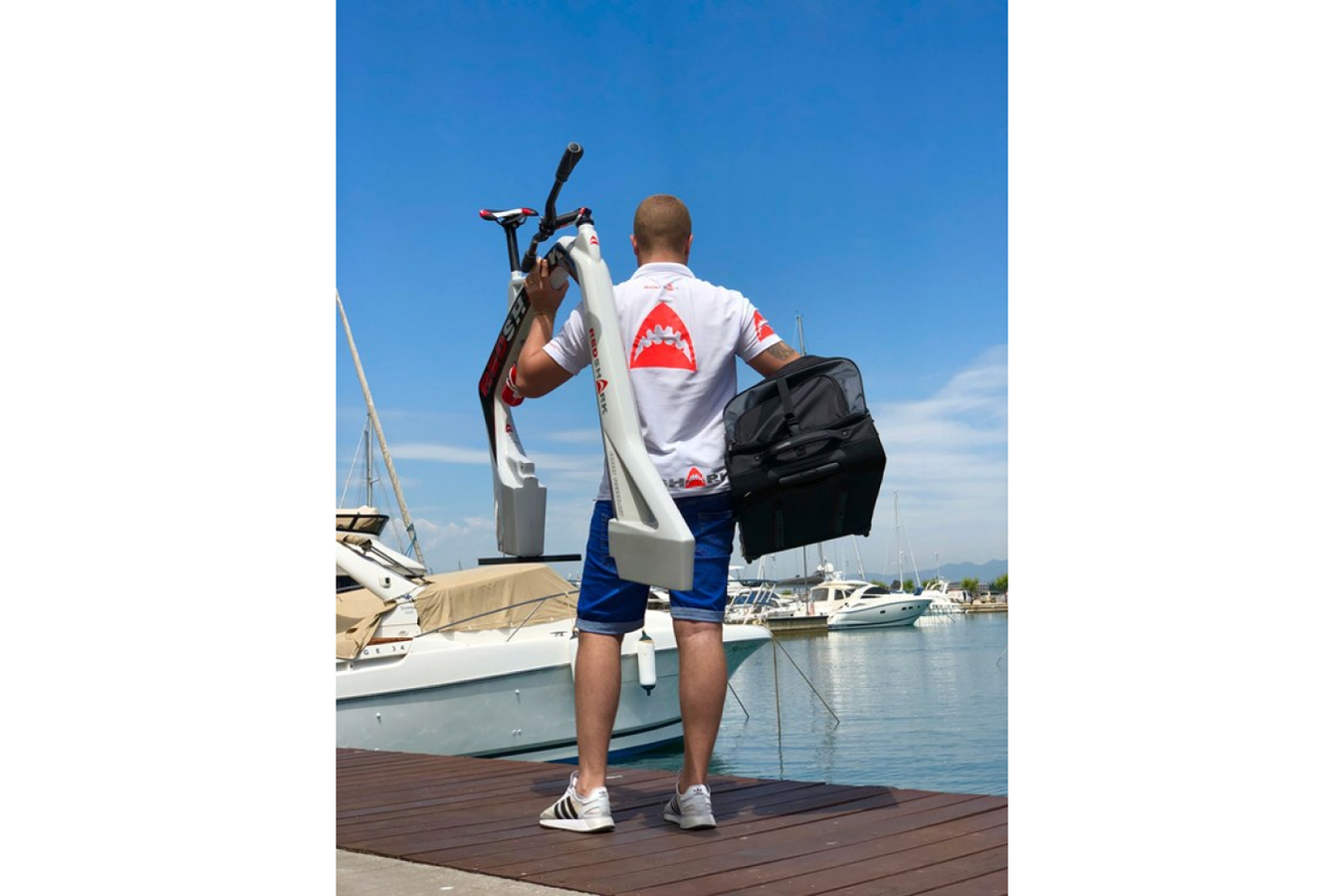 Person holding the Red Shark Aqua Cycle white body frame and  its other inclusions in the bag