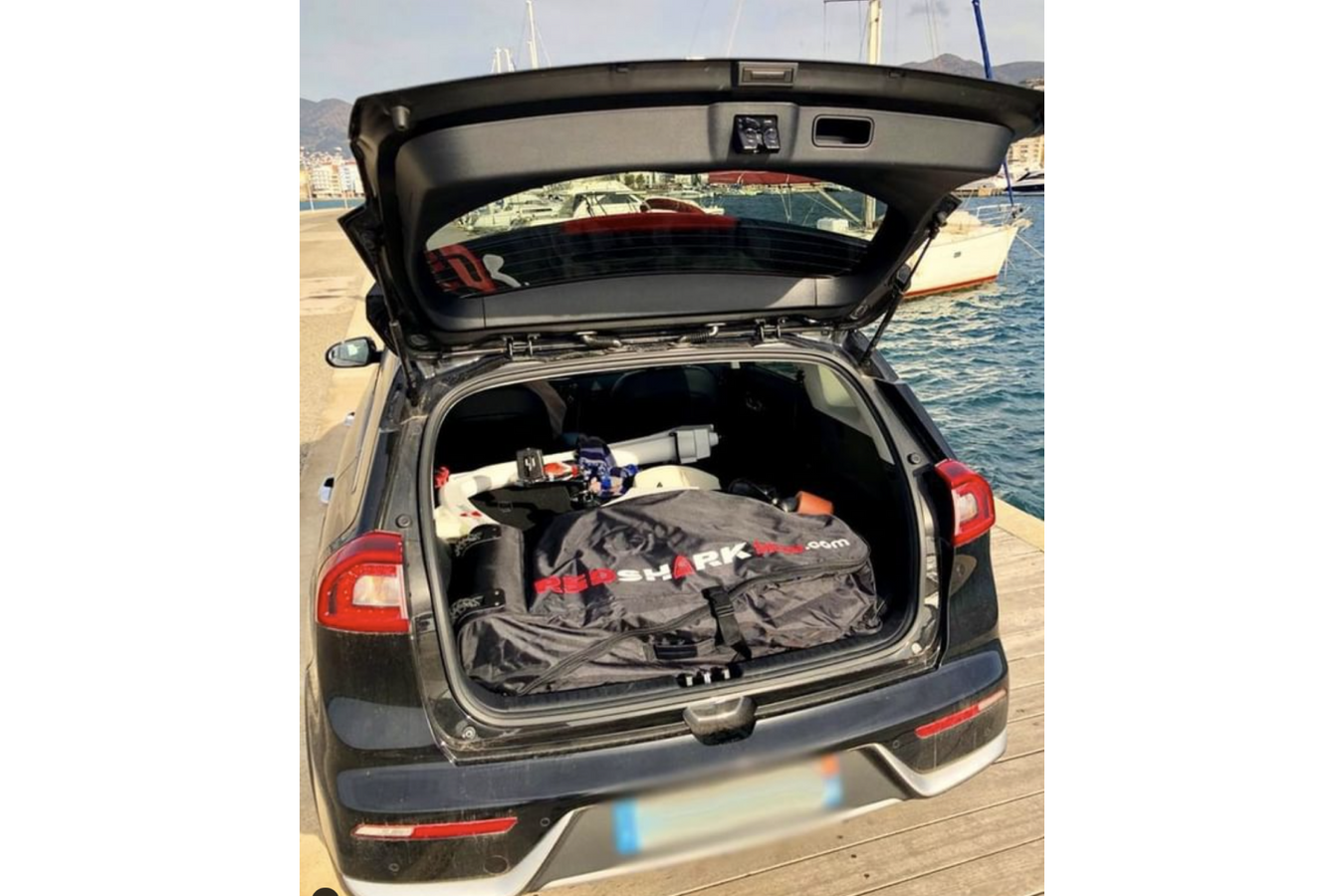 Red Shark Aquatic Bicycle inside its travel bag in the car's trunk